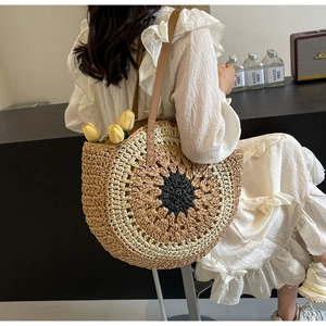 Detail showing handwoven sunflower-shaped tote bag with brown leather strap and texture