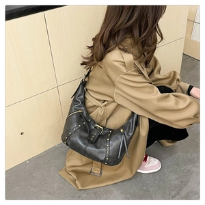 Détail du sac hobo vintage gris foncé avec clous dorés et fermetures éclair latérales