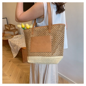 Detail shot of handwoven paper rope tote bag featuring a contrast leather pocket and strap