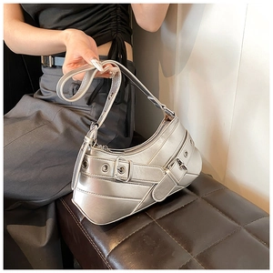 Macro shot of silver mirror-finish PU shoulder bag with metal eyelet strap details