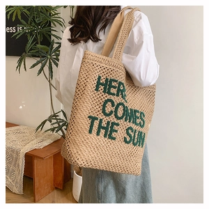 Broderie détaillée sur grand sac cabas en paille tissée avec lettrage vert style plage