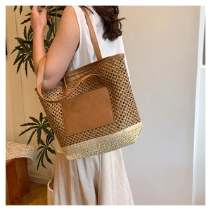Close-up of woven straw tote bag featuring brown leather trim and detailed stitching textures