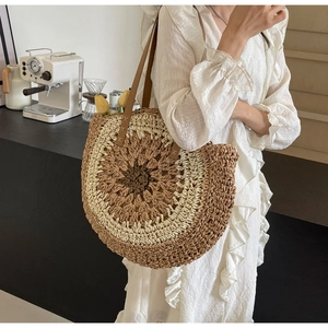 Detail of hand-woven circular tote with leather handles and intricate cross-stitching