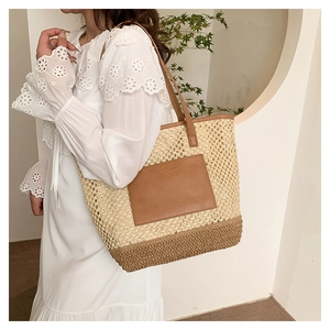 Detail showing woven mesh paper rope texture and brown leather patch on summer beach bag
