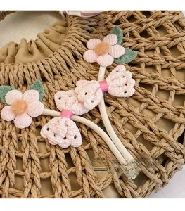 Detailed view of floral hair accessories with fabric texture on a woven straw bag