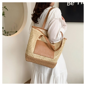Detail of straw woven tote with white mesh, brown leather pocket, and sturdy PU handles