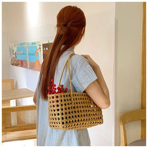Detailed view of caramel woven hollow handbag with double handles in a cafe setting