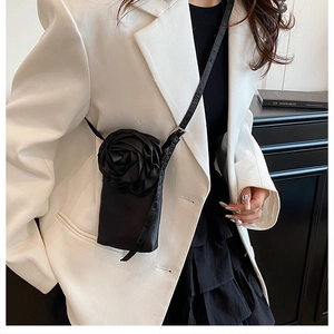 Détail du sac de téléphone en soie noire avec une grande fleur de rose 3D faite à la main