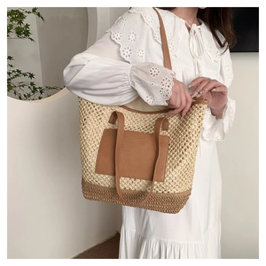 Detail of hollow woven paper rope tote bag with leather pocket and shoulder straps