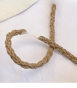 Detailed macro view of the woven long shoulder strap in light brown natural fiber