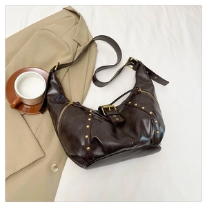 Détail du sac hobo rétro marron foncé avec clous dorés, fermetures et bandoulière