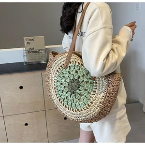 Detail of woven straw tote bag with brown leather straps and colorful spiral pattern texture