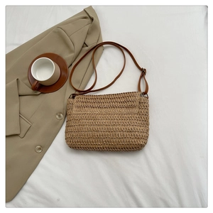 Detailed close-up showing the intricate woven texture and leather strap of this straw bag