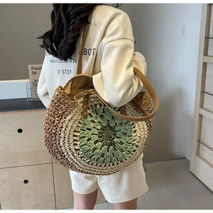 Detail of hand-crocheted mandala straw tote bag with green accents and brown PU shoulder strap