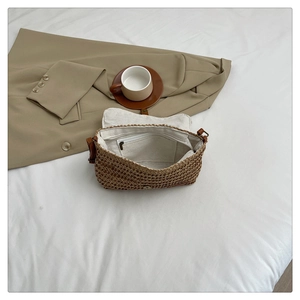 Detailed interior view of a straw beach bag featuring a fabric lining and a zipper pocket