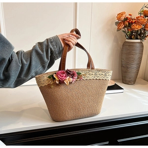 Detail of straw tote bag featuring delicate lace edges and pink floral decorations