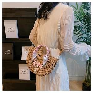 Detail of straw bag with flower charms, silk scarf handle, and inner drawstring lining