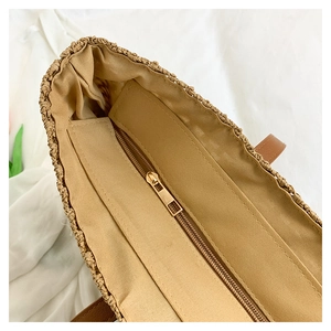 Detailed view of straw beach tote interior with durable fabric lining and gold zipper closure