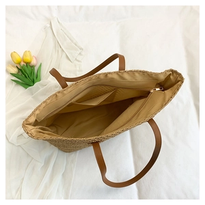 Top view of woven straw tote bag showing internal zipper pocket and spacious lining