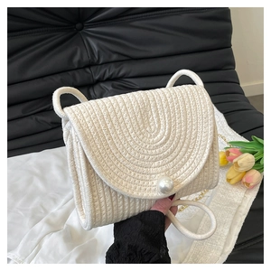 Handmade cream woven straw crossbody bag with large pearl closure and gold chain strap