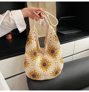 Detailed macro view of handmade crochet sunflower hobo bag with intricate knit texture