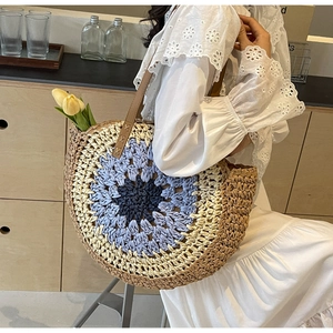 Detail of colorful hand-woven straw tote bag with leather strap and tulip decor