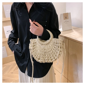 Detailed macro view of beige semi-circular woven straw bag with mesh pattern design