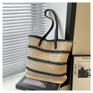 Detail of striped woven tote bag with premium leather straps and secure gold zipper closure