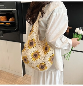 Detail of handmade crochet shoulder bag featuring sunflower patterns and soft texture