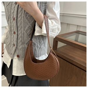 Braune gewebte Halbmondtasche am Modell für einen stilvollen Retro-Look