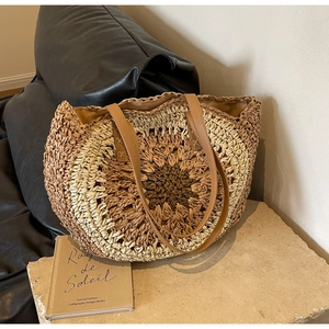 Handwoven straw tote bag with sunflower pattern and long brown leather handles