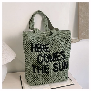 Green woven crochet tote bag with black Here Comes The Sun embroidery and top handles