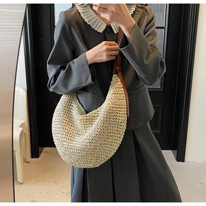 Detail of beige woven hobo bag showing the fine texture and adjustable brown leather strap
