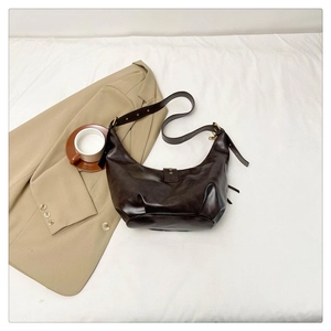 Vue détaillée de dessus du sac hobo en cuir marron foncé avec boucles dorées