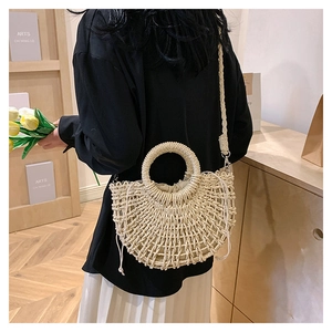 Detail of half-moon straw bag with round handle and drawstring lining on a model
