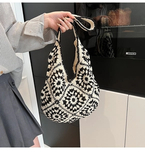 Detail of handmade crochet shoulder bag featuring black and white geometric floral patterns