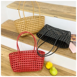 Hollow woven beach tote bags in red, black, and khaki on wooden stairs
