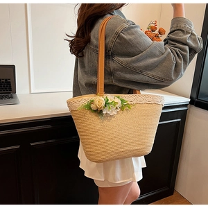 Detail of hand-woven straw tote with lace trim and faux flowers for a boho aesthetic