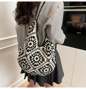 Detail of handmade crochet shoulder bag featuring black and white bohemian knit patterns