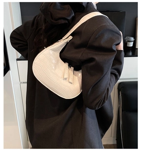 Detailed back view of white crocodile pattern crescent underarm bag worn by model
