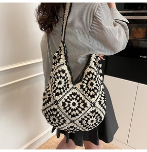 Detailed view of handmade crochet tote bag featuring black and white sunflower patterns