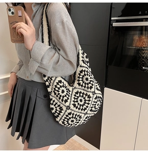 Close-up of handmade crochet tote bag with black and white floral knit patterns