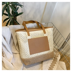 Hollow straw shoulder bag in cream and brown with durable leather handles