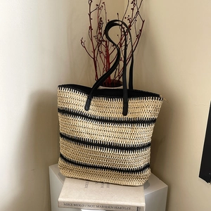Handmade straw woven tote bag with black stripes and leather straps for summer beach vacation