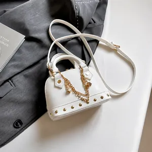 Detailansicht der weißen Muscheltasche mit goldenen Ketten und Metallnieten-Besatz