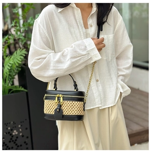 Detailed close-up of retro bamboo weave and black leather bag with gold chain strap