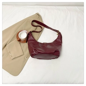 Détail d'un sac hobo bordeaux avec boucle en métal doré vintage et bandoulière réglable