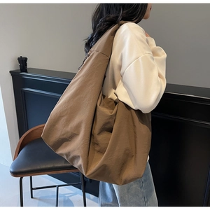 Detalle del bolso tote de lona marrón de gran capacidad con textura plisada natural