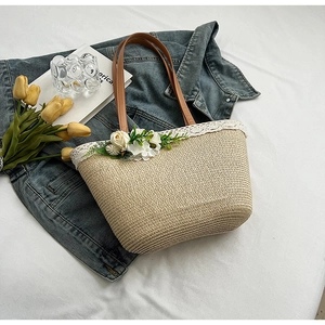 Straw woven tote bag with brown leather handles and white lace floral edge detail