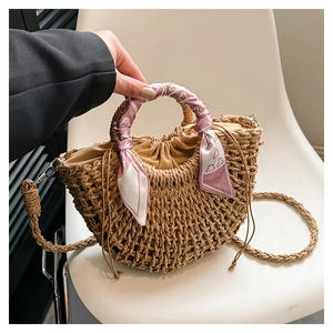 Detail of straw woven handbag with floral silk scarf handle and drawstring lining